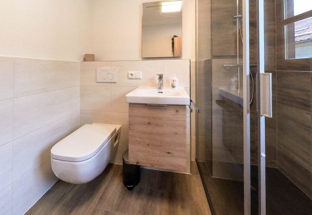 WC, Badezimmerschrank und Duschkabine